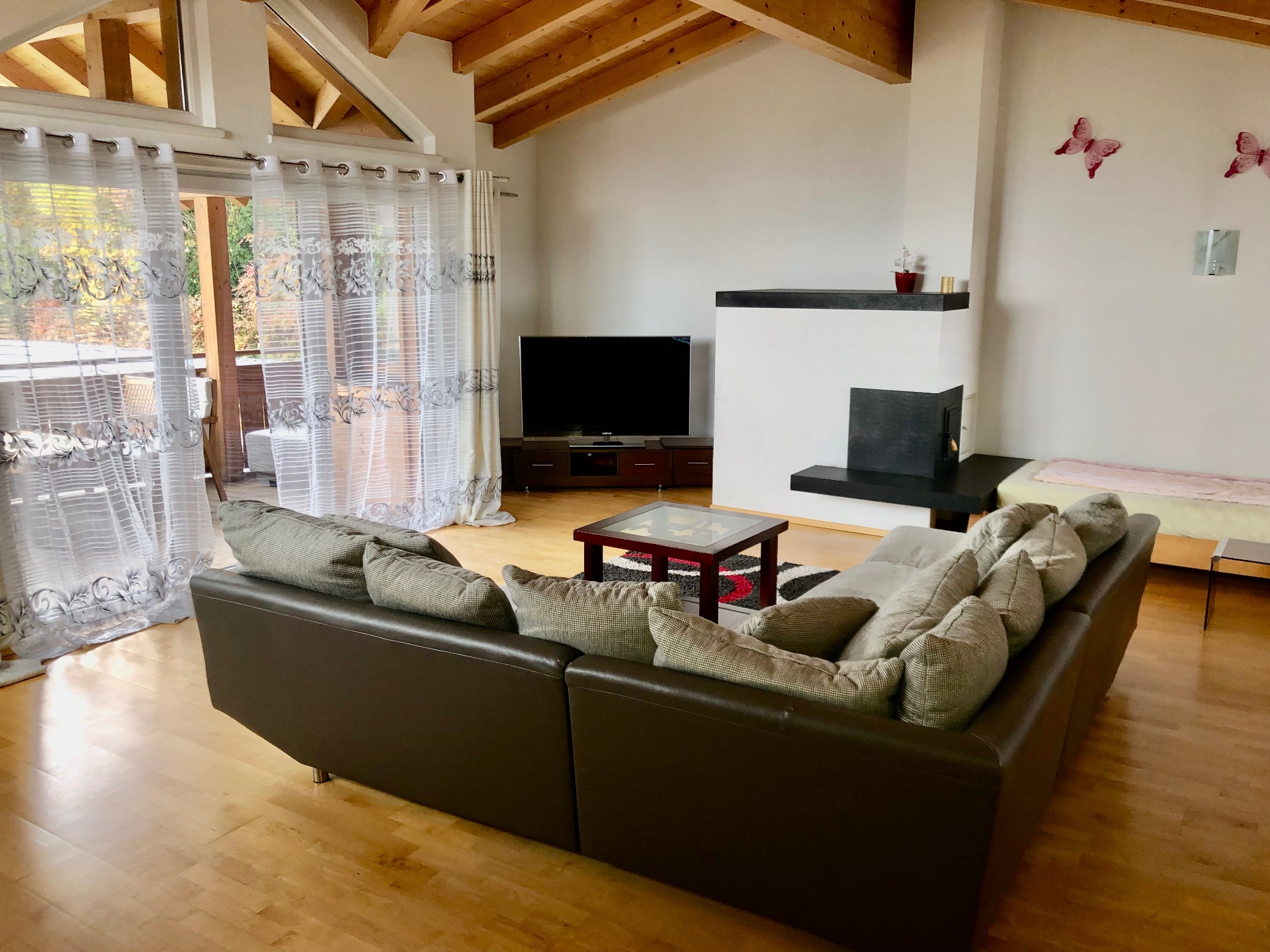 Przestronny salon apartamentu z kominkiem i drewnianym stropem
